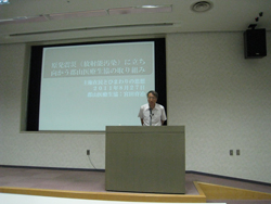 講演をおこなう宮田郡山医療生協専務。8月27日に愛媛医療生協でも講演を行ったので、スライドの日付が27日になっています。
